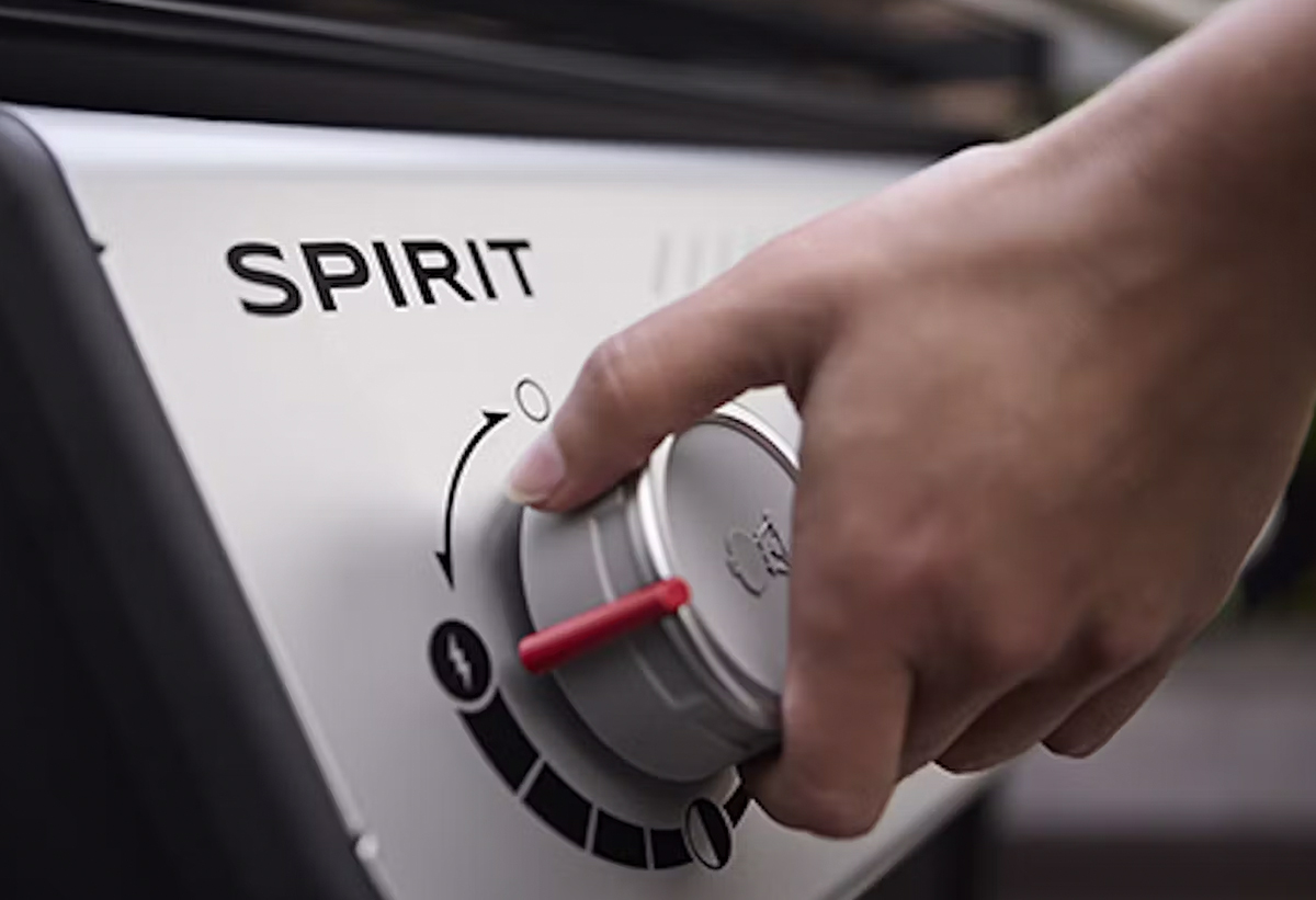 Απεικονίζεται ένα χέρι να ανάβει την ψησταριά από τον διακόπτη.